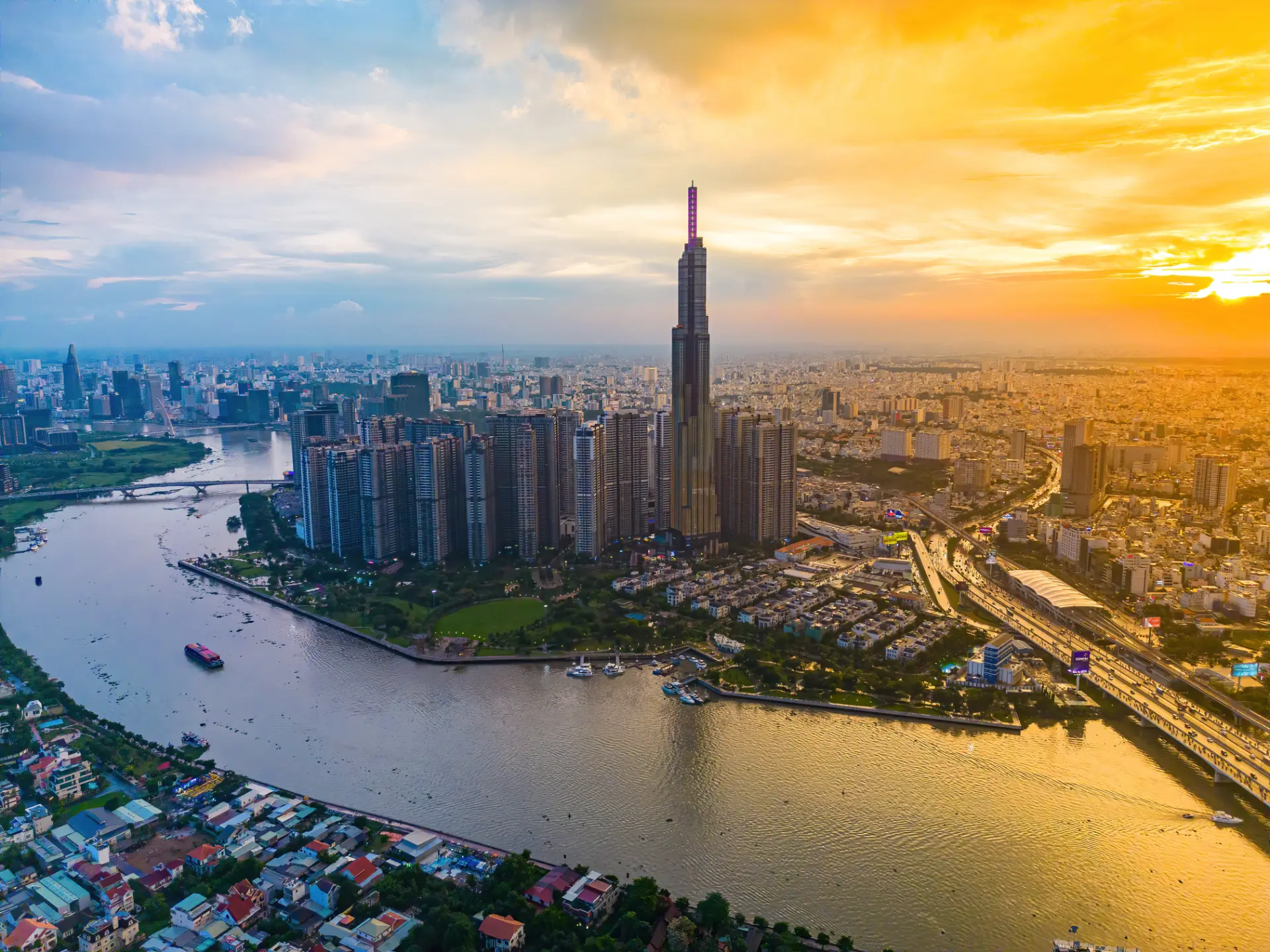 Aerial sunset view of Landmark 81, the Saigon River bridges, and the Ho Chi Minh City skyline